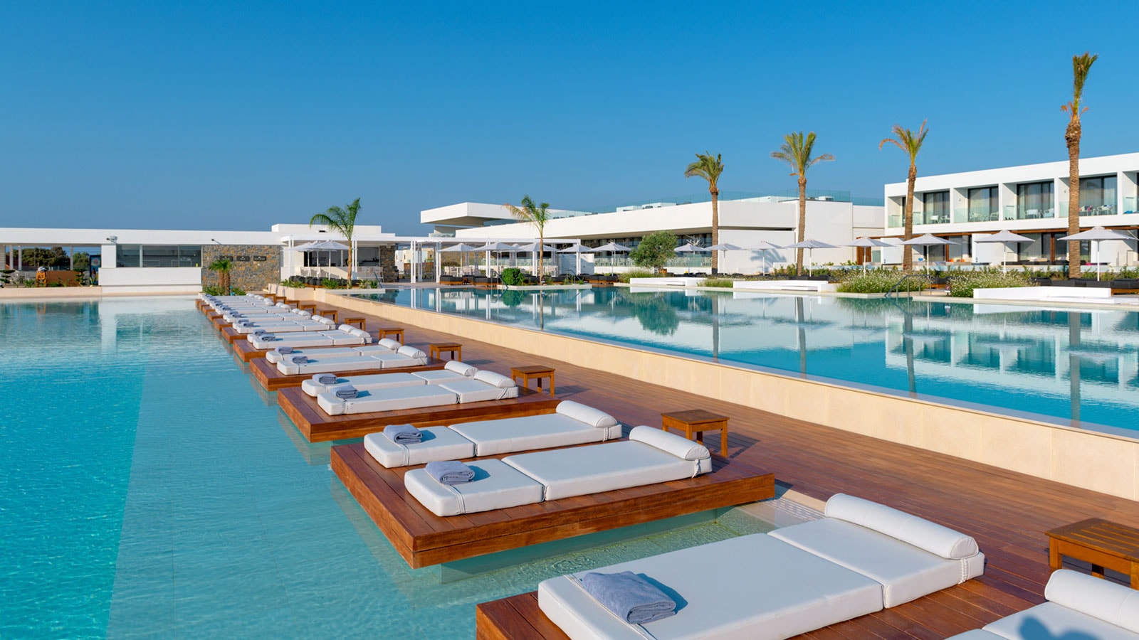 Pool med liggestole i ferieparadis på Rhodos med grøn profil